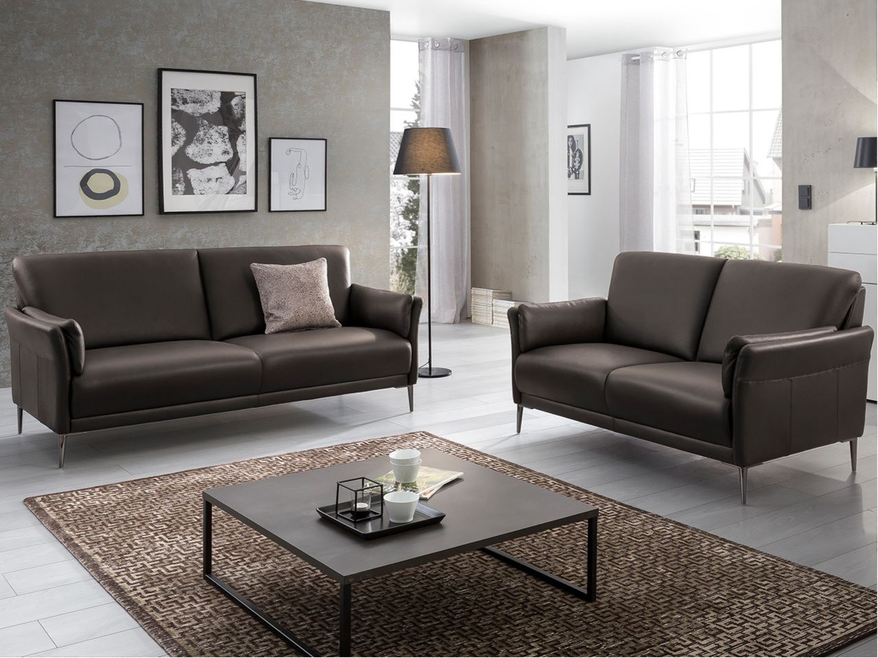 Ein Wohnzimmer mit einem Sofa und einem Loveseat, gemütlich und einladend eingerichtet.